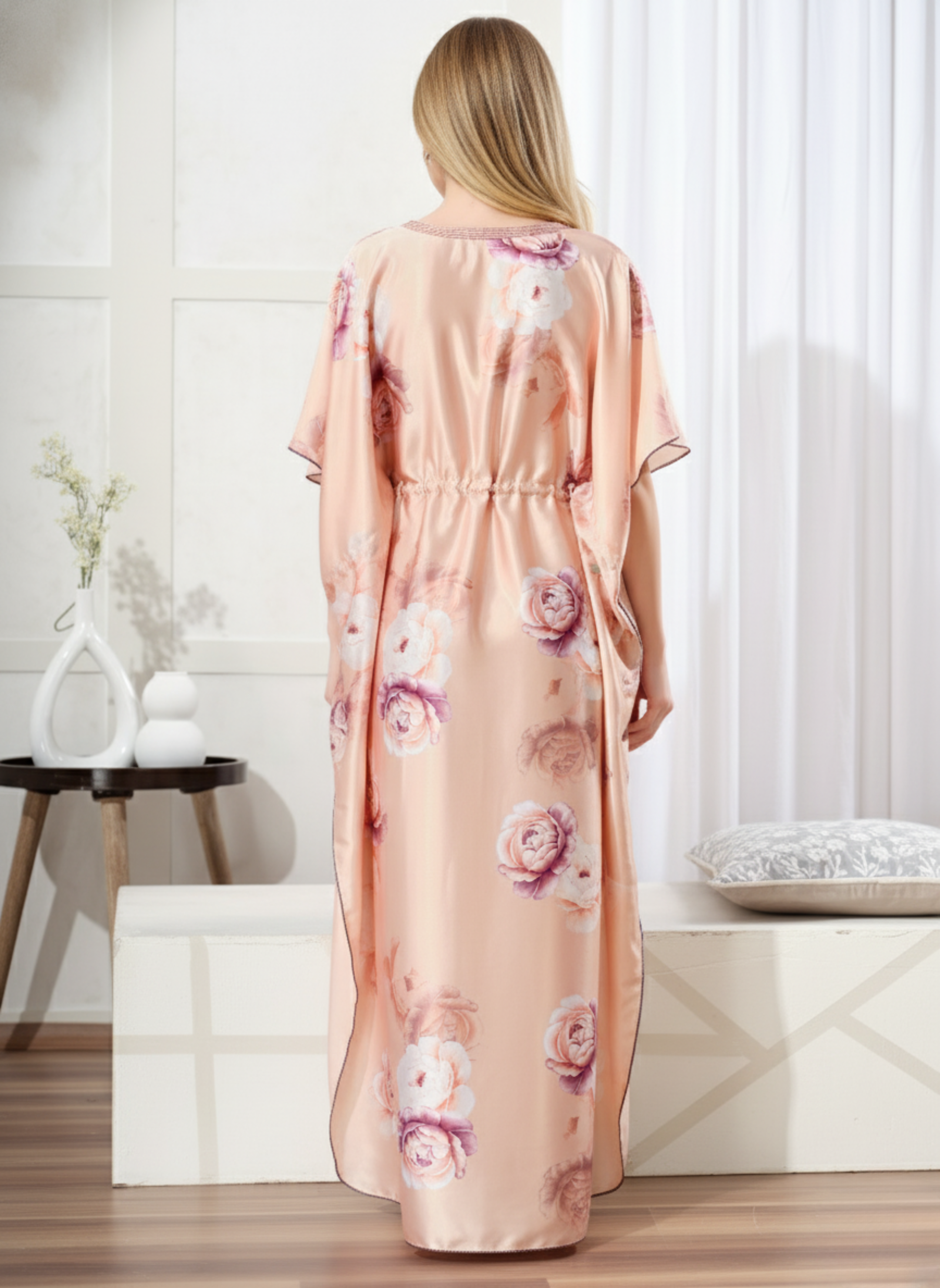 Back view of pastel peach floral satin kaftan showing flowy full length fit and contrast hem trim