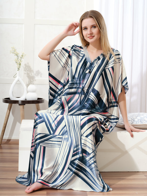 Model sitting wearing cream and navy geometric print satin kaftan for women with pink accents and drawstring waist