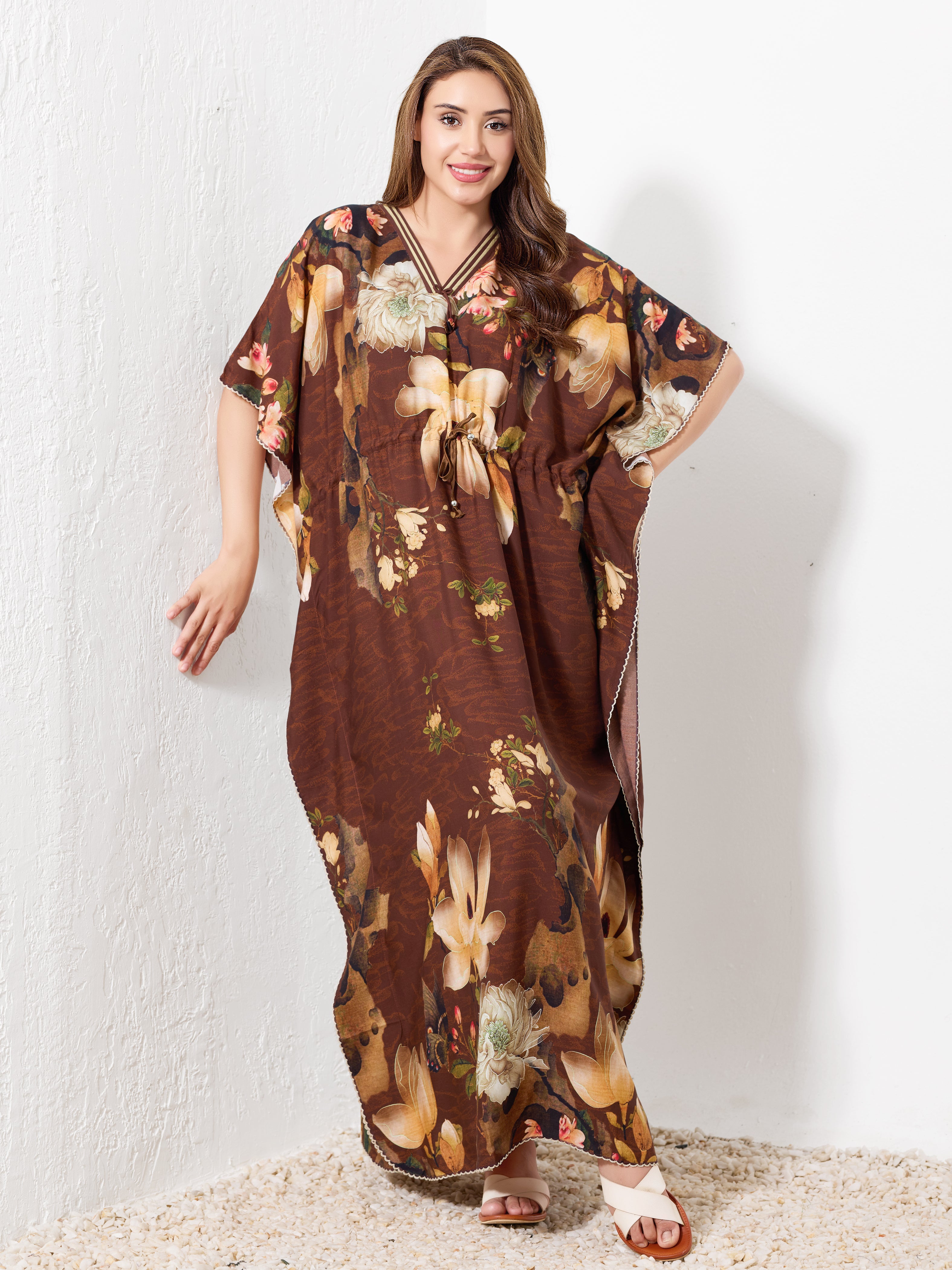 Model standing wearing brown premium cotton kaftan for women with beige floral print and drawstring waist