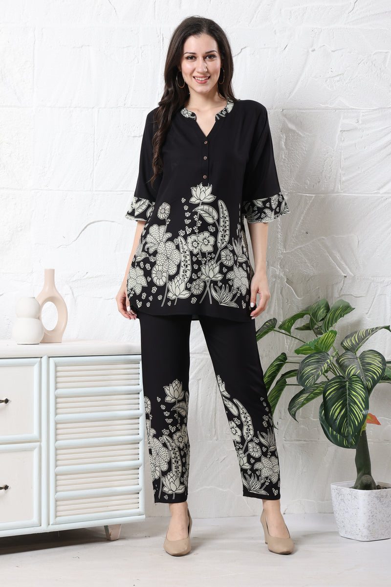 Model wearing black linen floral co-ord set for women with white botanical print on tunic and straight trousers